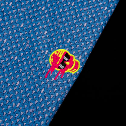 SWAG Golf x Peter Millar blue short sleeve performance golf polo shirt with embroidered sideways melting skull over the left chest.